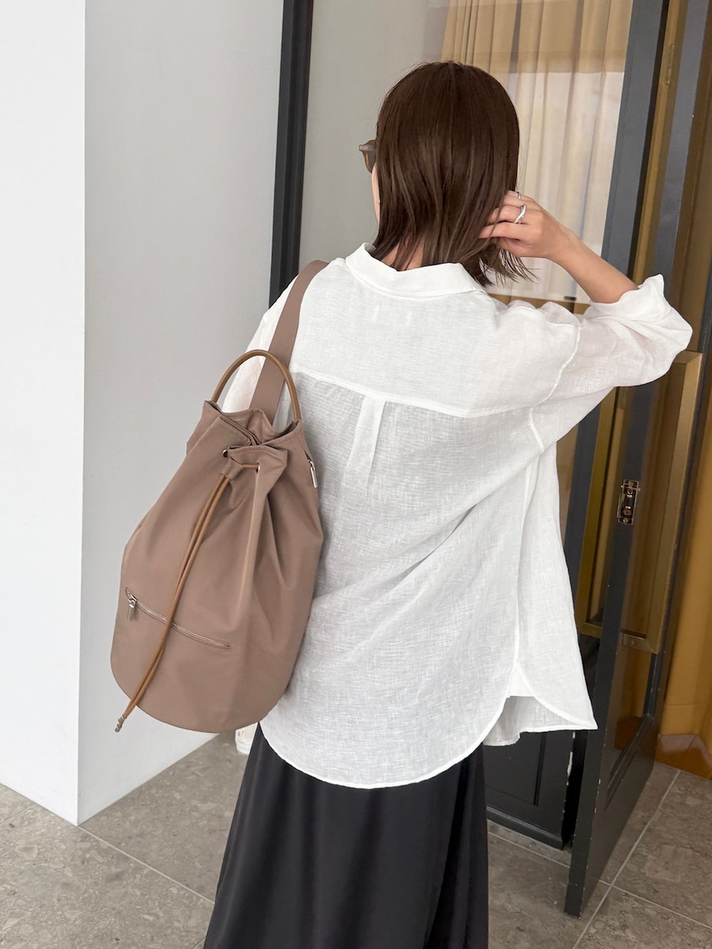 ホワイト系のシャツ/ブラウス、ブラック系のスカート、ブラウン系のタンクトップを着用したレディースの夏コーディネートの8枚目の写真