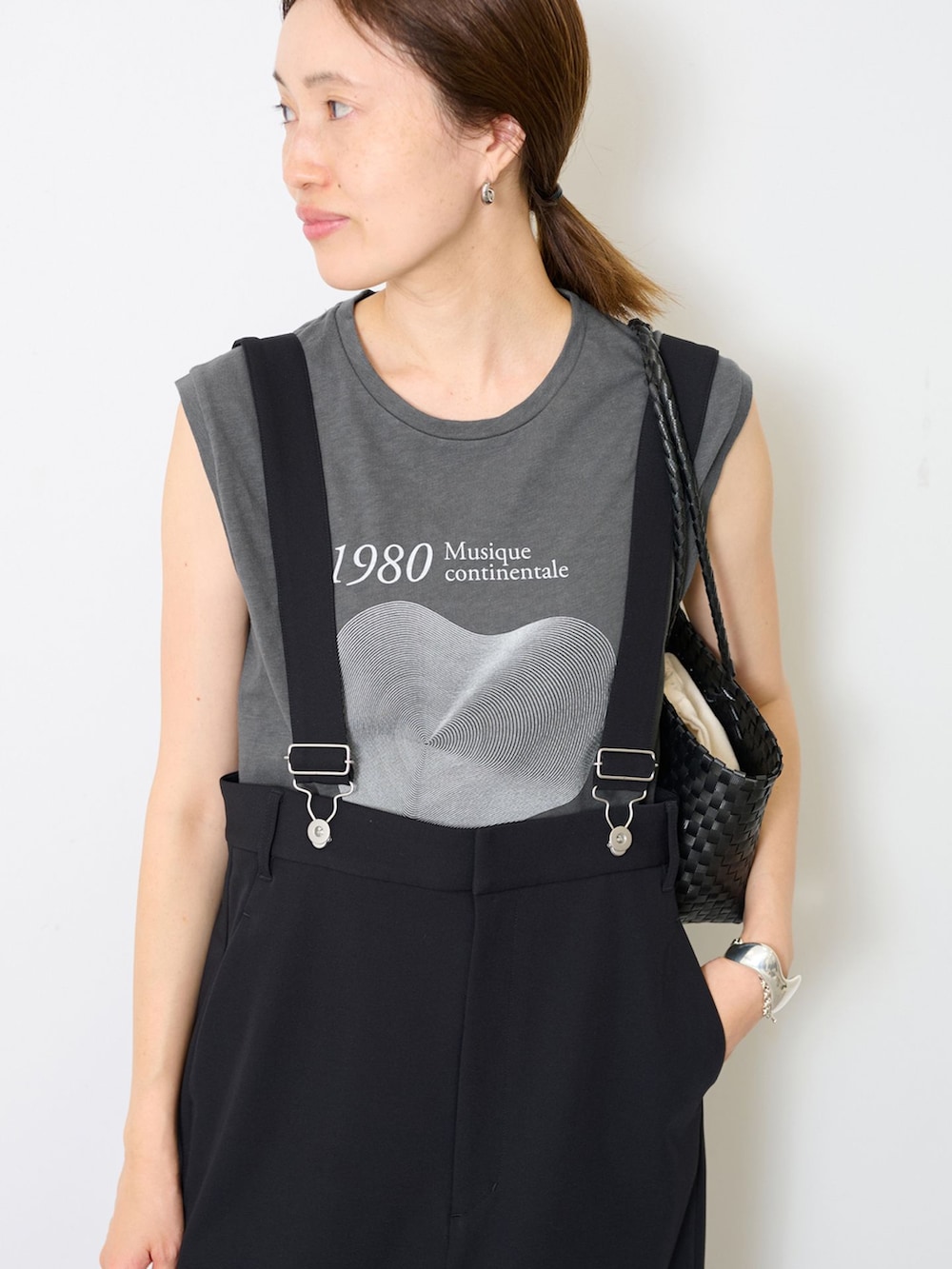 ブラック系のスカート、グレー系のTシャツ/カットソー、ブラック系のかごバッグを着用したレディースの夏コーディネートの5枚目の写真