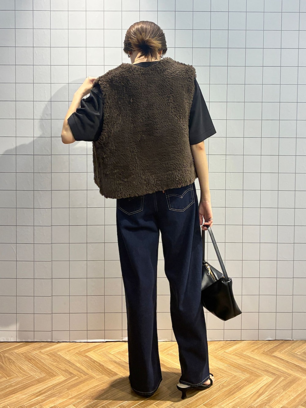 ブルー系のデニムパンツ、ブラック系のTシャツ/カットソー、ブラウン系のベストを着用したレディースの夏コーディネートの5枚目の写真