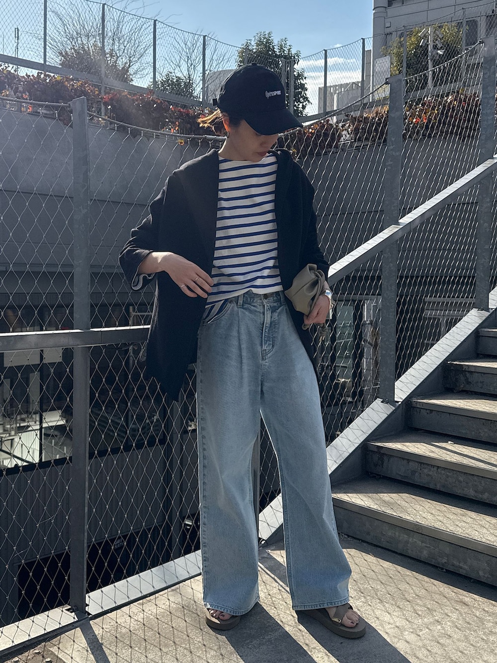 ブルー系のデニムパンツ、ブルー系のTシャツ/カットソー、ブラック系のカーディガン/ボレロを着用したレディースの春コーディネートの2枚目の写真