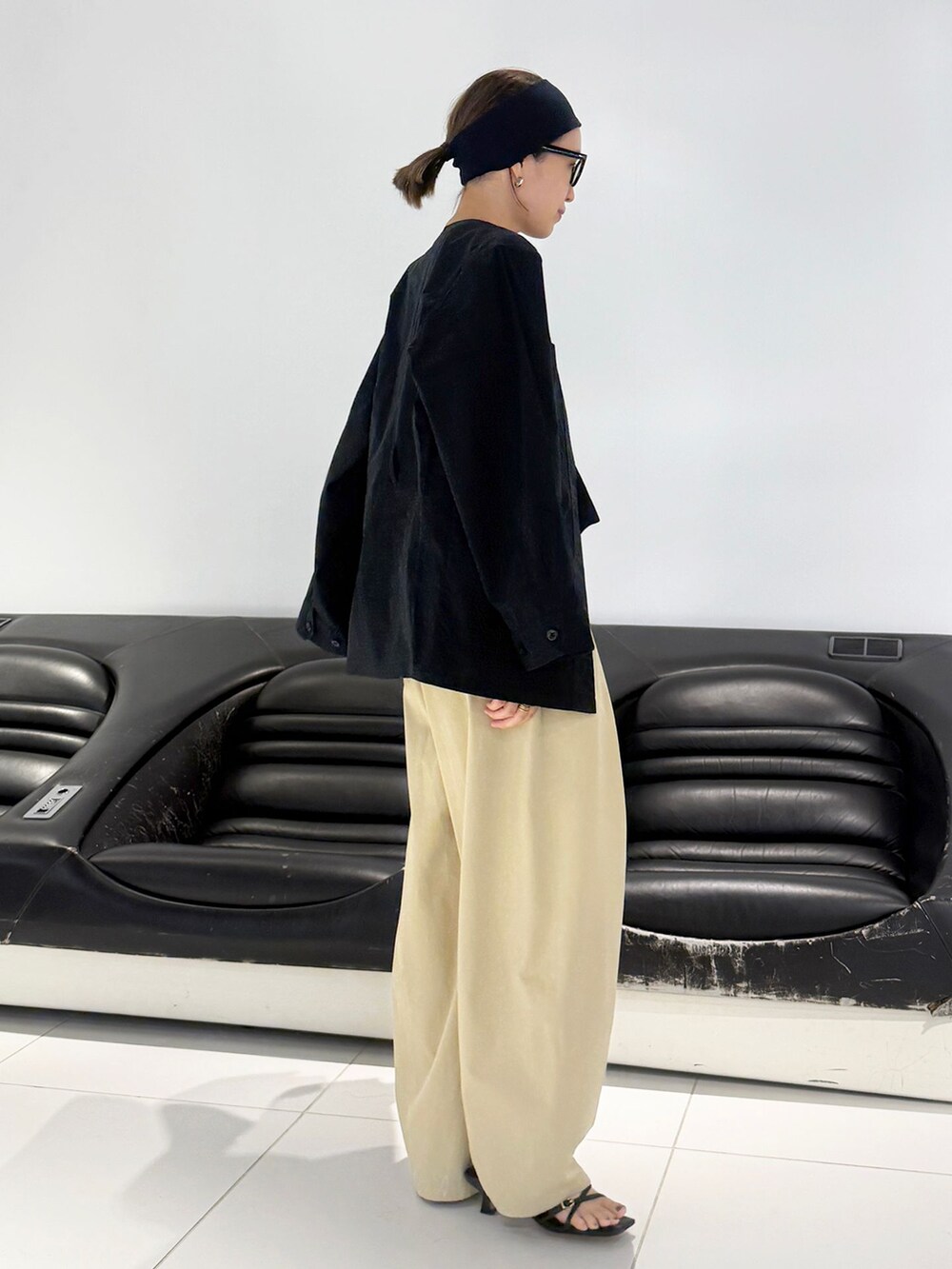 ベージュ系のチノパンツ、ブラック系のその他アウター、ブラック系のTシャツ/カットソーを着用したレディースの冬コーディネートの4枚目の写真