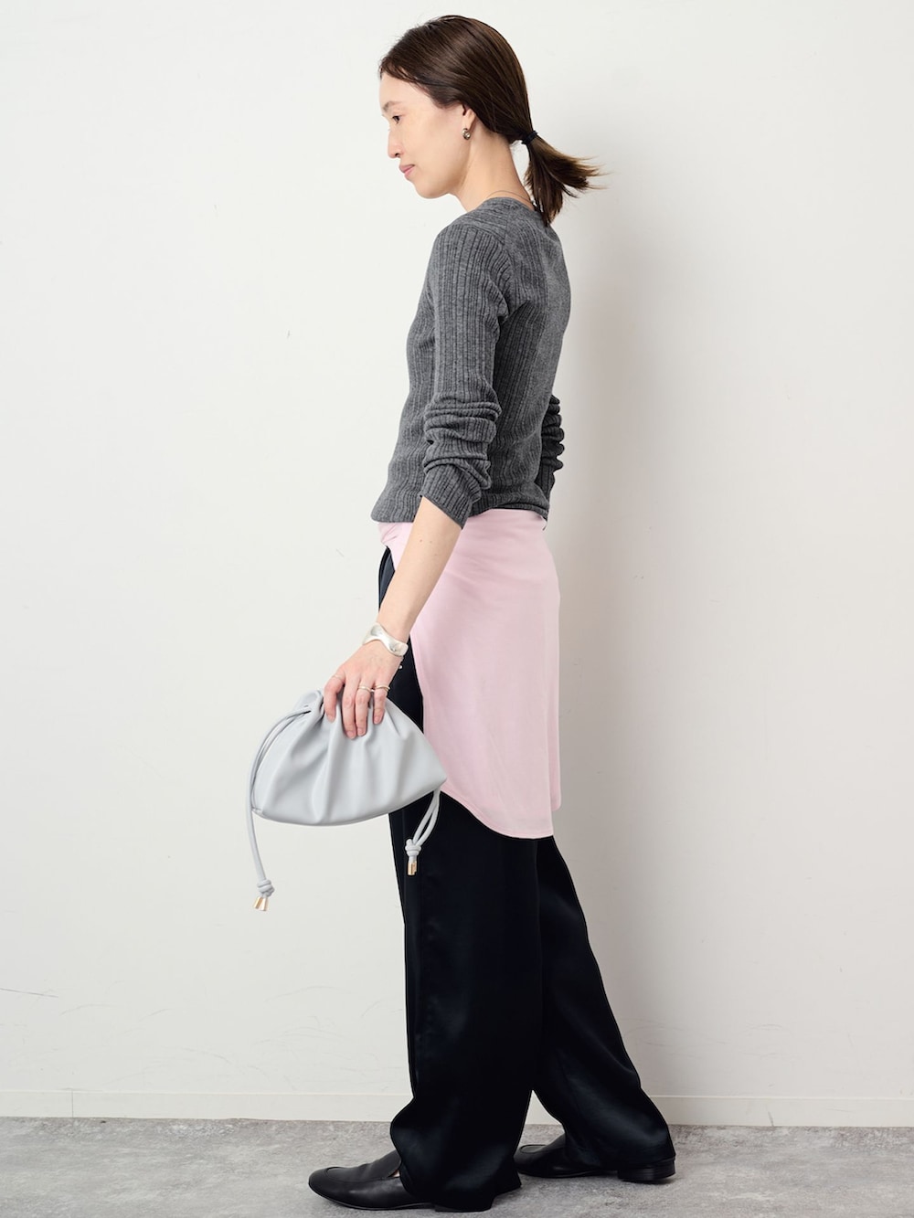 ブラック系のその他パンツ、グレー系のニット/セーター、ブルー系のクラッチバッグを着用したレディースの夏コーディネートの2枚目の写真