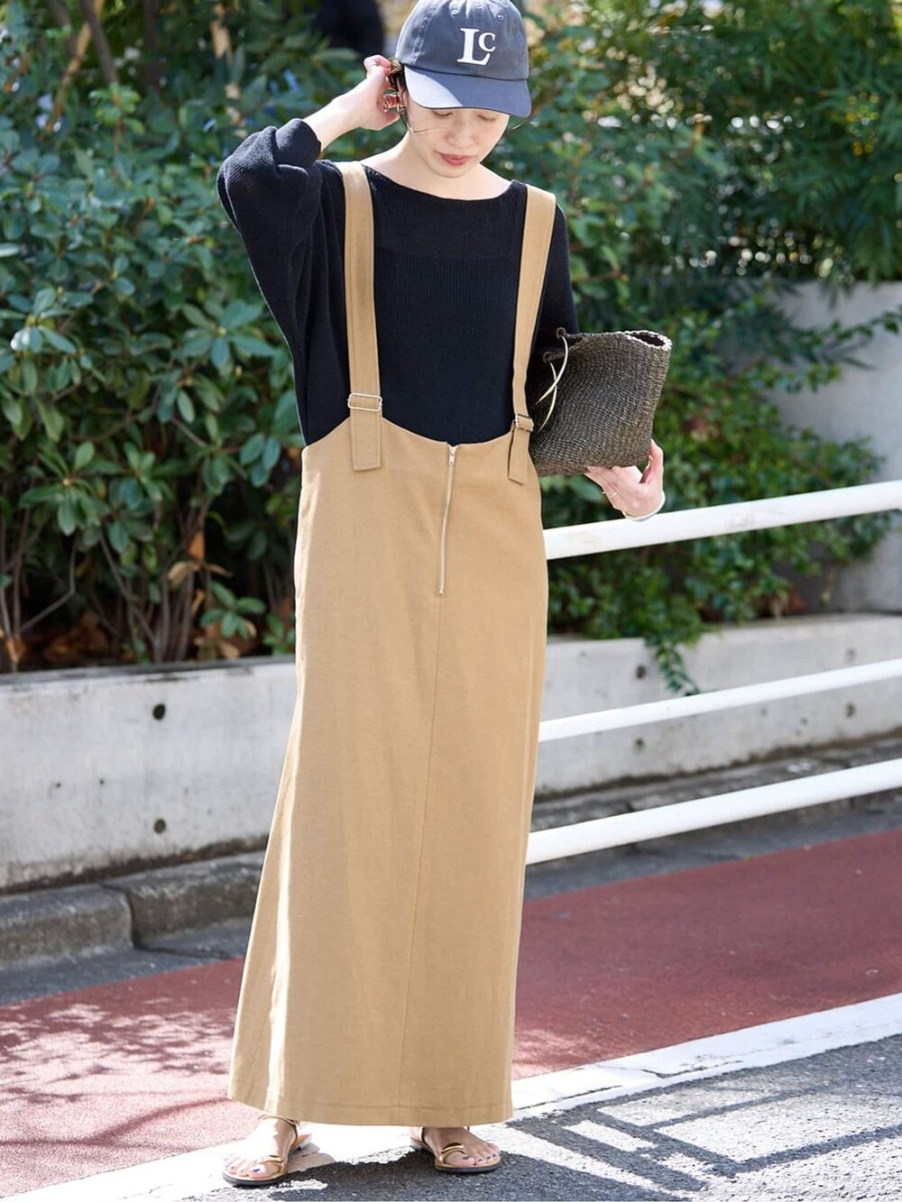 ベージュ系のワンピース、ブラック系のニット/セーター、ベージュ系のサンダルを着用したレディースの春コーディネートの2枚目の写真