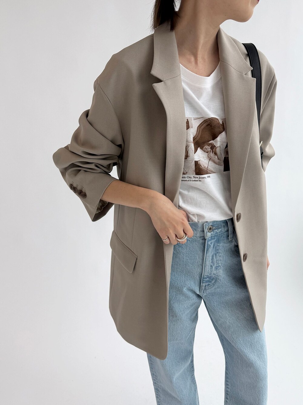 ブルー系のデニムパンツ、ベージュ系のテーラードジャケット、ホワイト系のTシャツ/カットソーを着用したレディースの春コーディネートの7枚目の写真