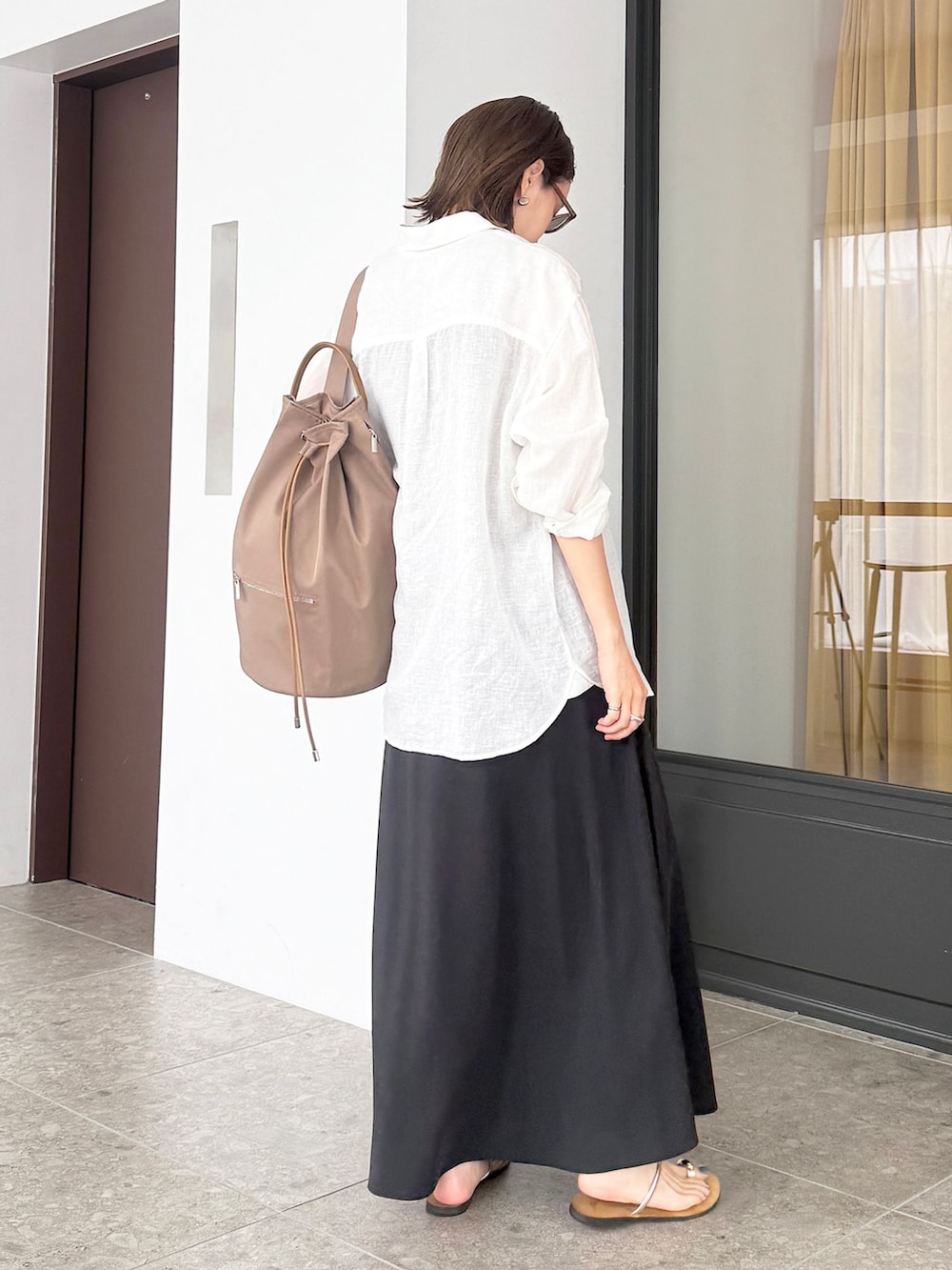 ホワイト系のシャツ/ブラウス、ブラック系のスカート、ブラウン系のタンクトップを着用したレディースの夏コーディネートの4枚目の写真