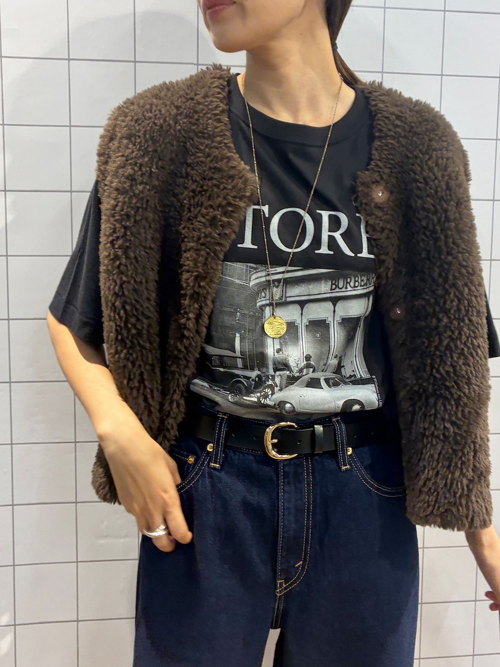 ブルー系のデニムパンツ、ブラック系のTシャツ/カットソー、ブラウン系のベストを着用したレディースの夏コーディネートの7枚目の写真