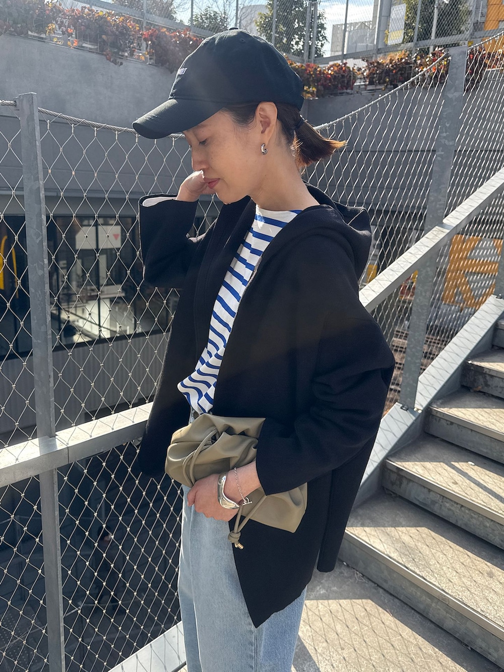 ブルー系のデニムパンツ、ブルー系のTシャツ/カットソー、ブラック系のカーディガン/ボレロを着用したレディースの春コーディネートの5枚目の写真
