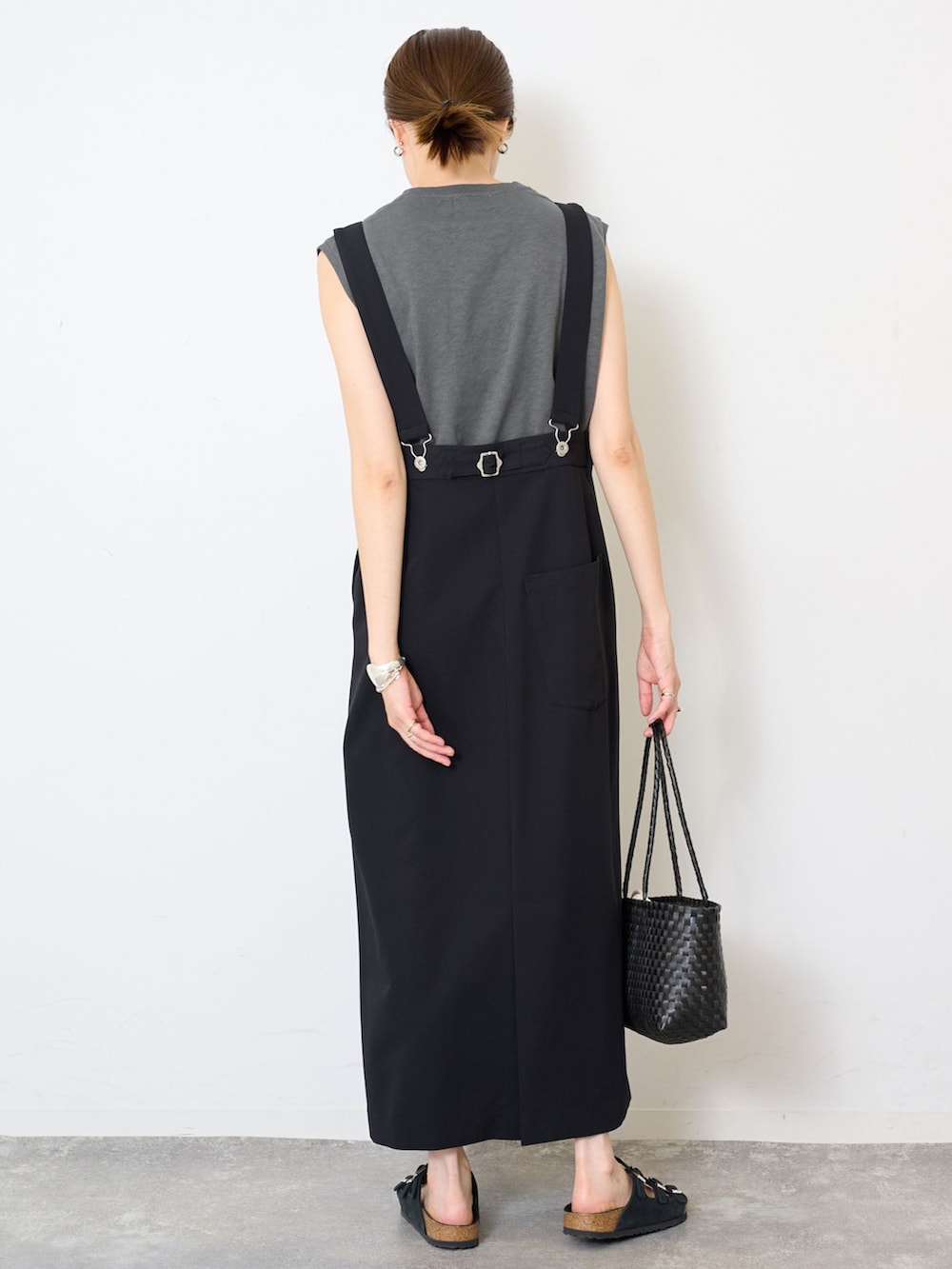 ブラック系のスカート、グレー系のTシャツ/カットソー、ブラック系のかごバッグを着用したレディースの夏コーディネートの3枚目の写真