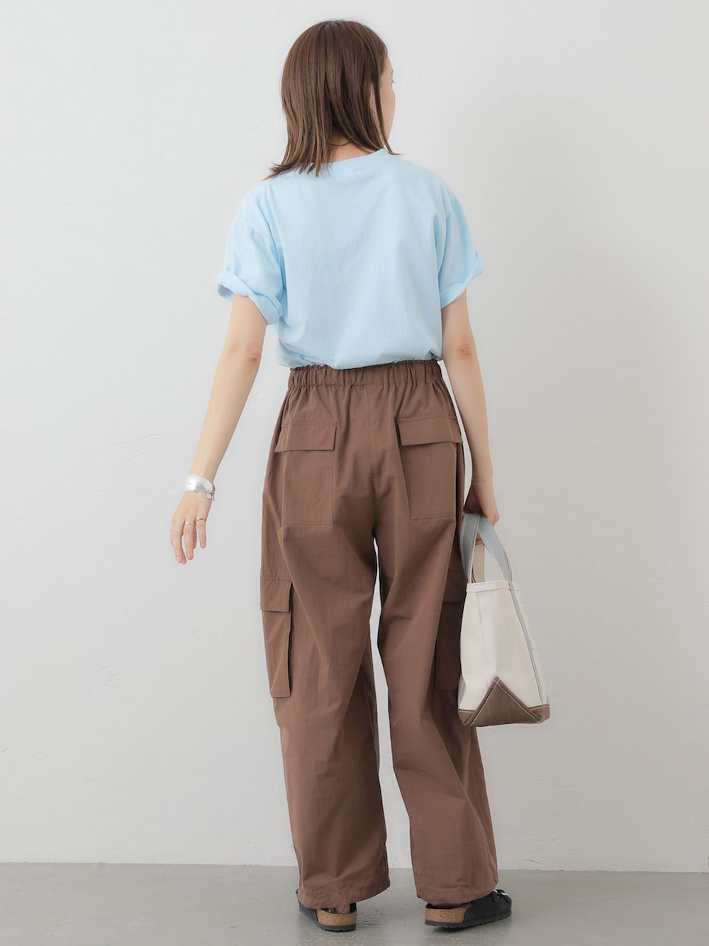 ブラウン系のカーゴパンツ、ブルー系のTシャツ/カットソー、ホワイト系のトートバッグを着用したレディースの夏コーディネートの4枚目の写真
