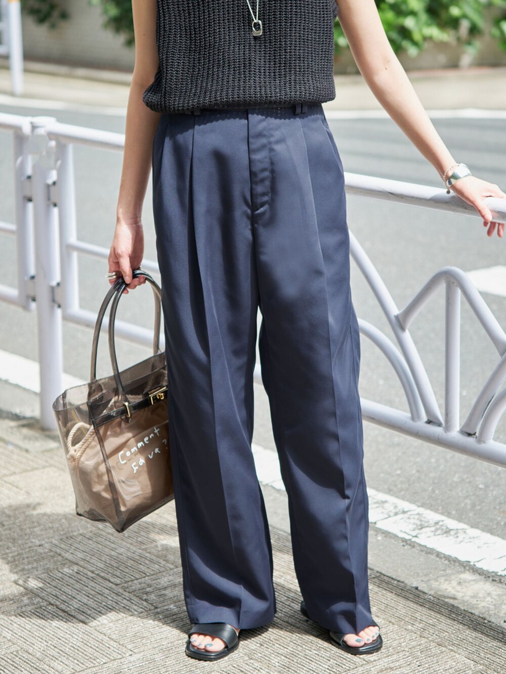 ブルー系のチノパンツ、ブラック系のニット/セーター、ブラック系のトートバッグを着用したレディースの春コーディネートの3枚目の写真