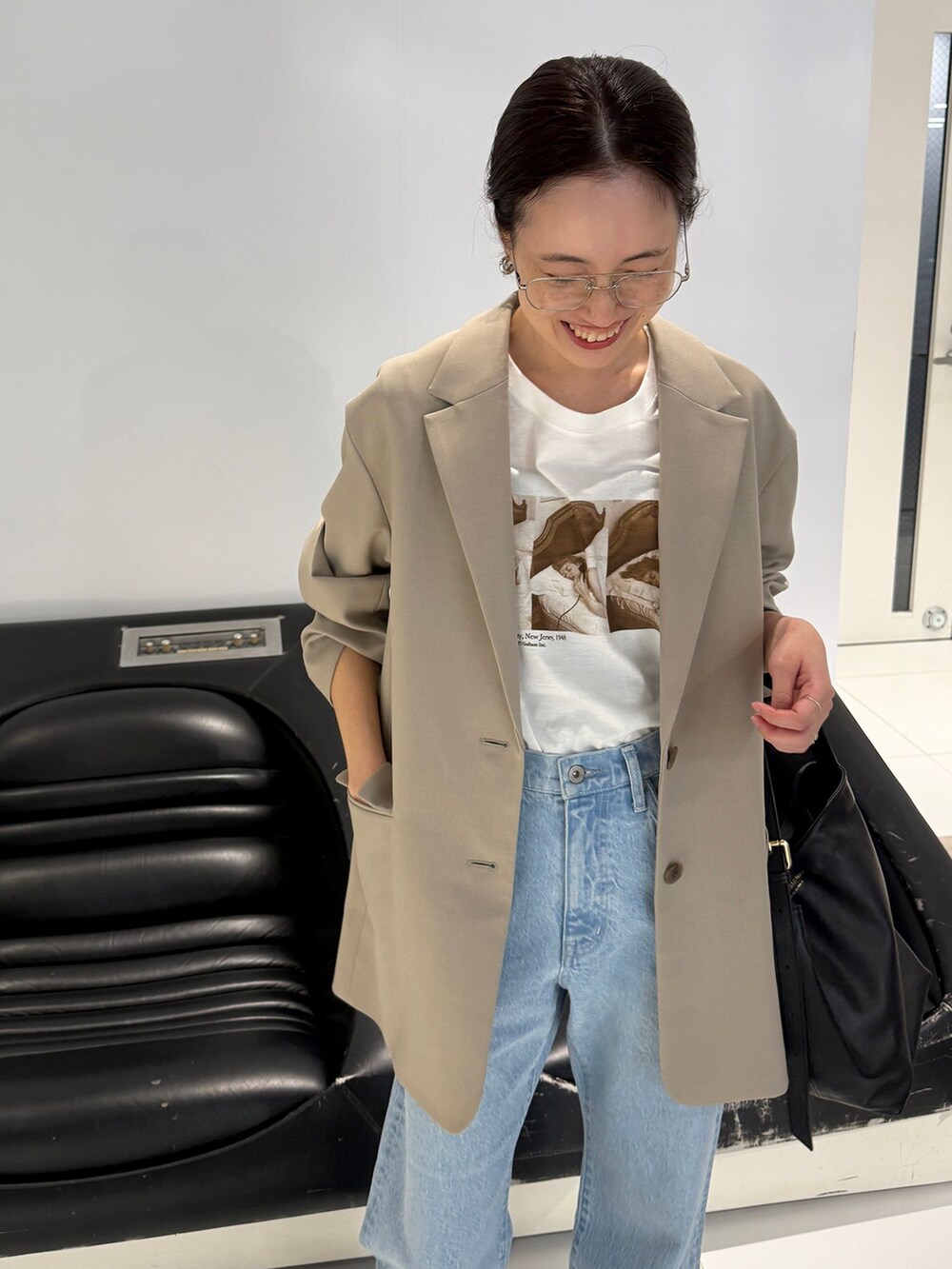 ブルー系のデニムパンツ、ベージュ系のテーラードジャケット、ホワイト系のTシャツ/カットソーを着用したレディースの春コーディネートの9枚目の写真