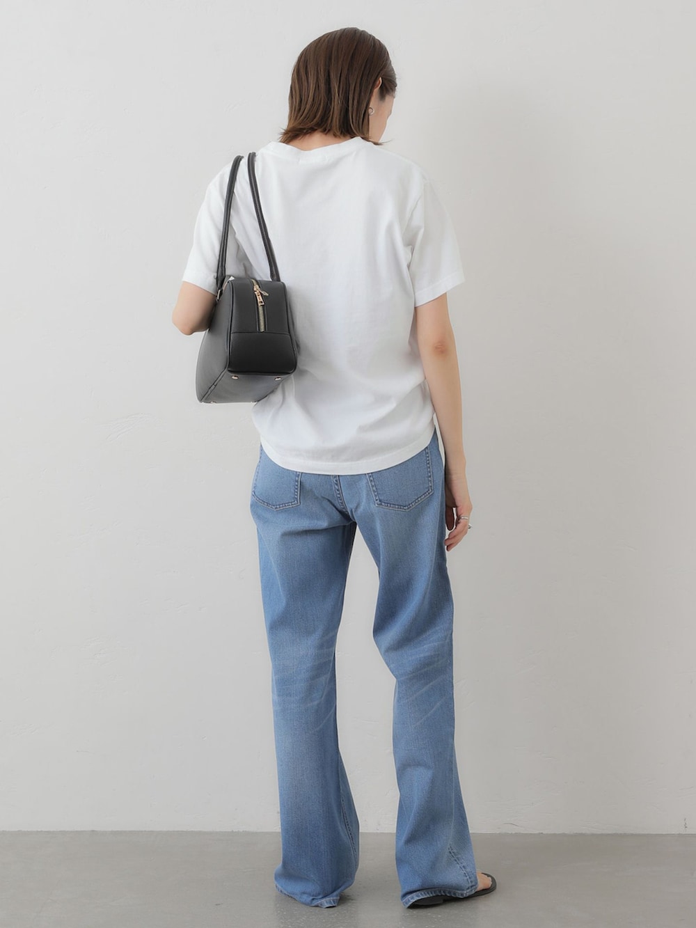 ブルー系のデニムパンツ、ホワイト系のTシャツ/カットソー、ブラック系のボストンバッグを着用したレディースの夏コーディネートの3枚目の写真