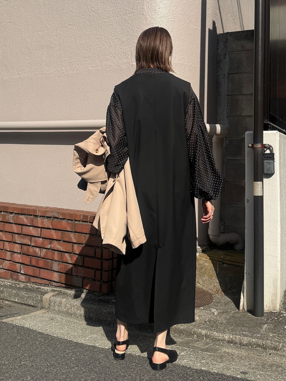 ベージュ系のトレンチコート、ブラック系のワンピース、ブラック系のシャツ/ブラウスを着用したレディースの春コーディネートの4枚目の写真
