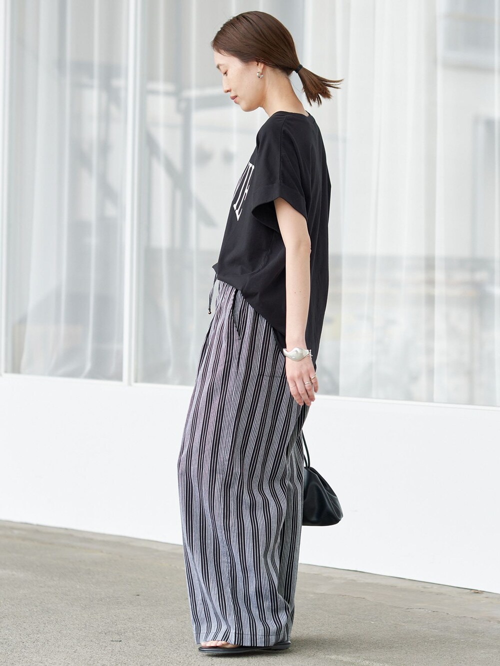 ブラック系のその他パンツ、ブラック系のTシャツ/カットソー、ブラック系のクラッチバッグを着用したレディースの夏コーディネートの2枚目の写真