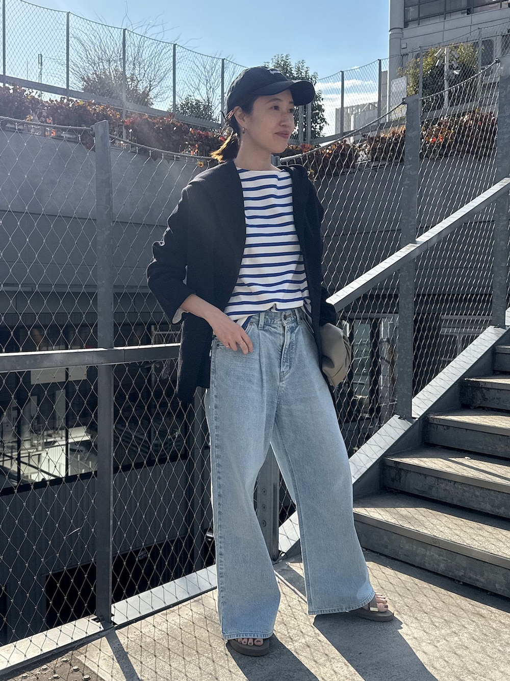 ブルー系のデニムパンツ、ブルー系のTシャツ/カットソー、ブラック系のカーディガン/ボレロを着用したレディースの春コーディネートの3枚目の写真
