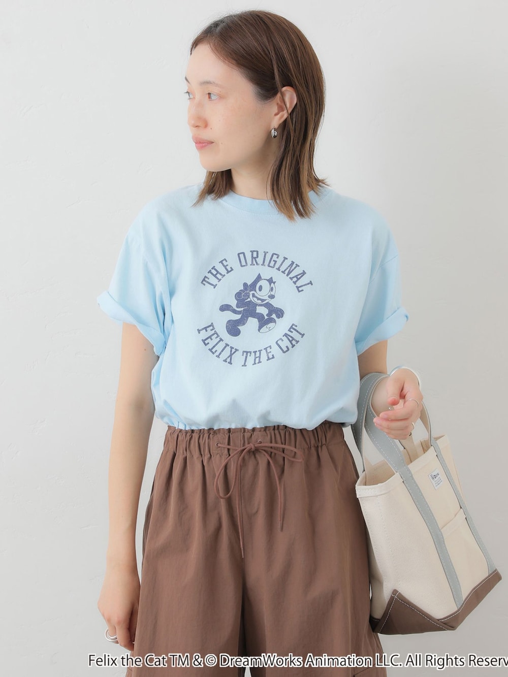 ブラウン系のカーゴパンツ、ブルー系のTシャツ/カットソー、ホワイト系のトートバッグを着用したレディースの夏コーディネートの5枚目の写真