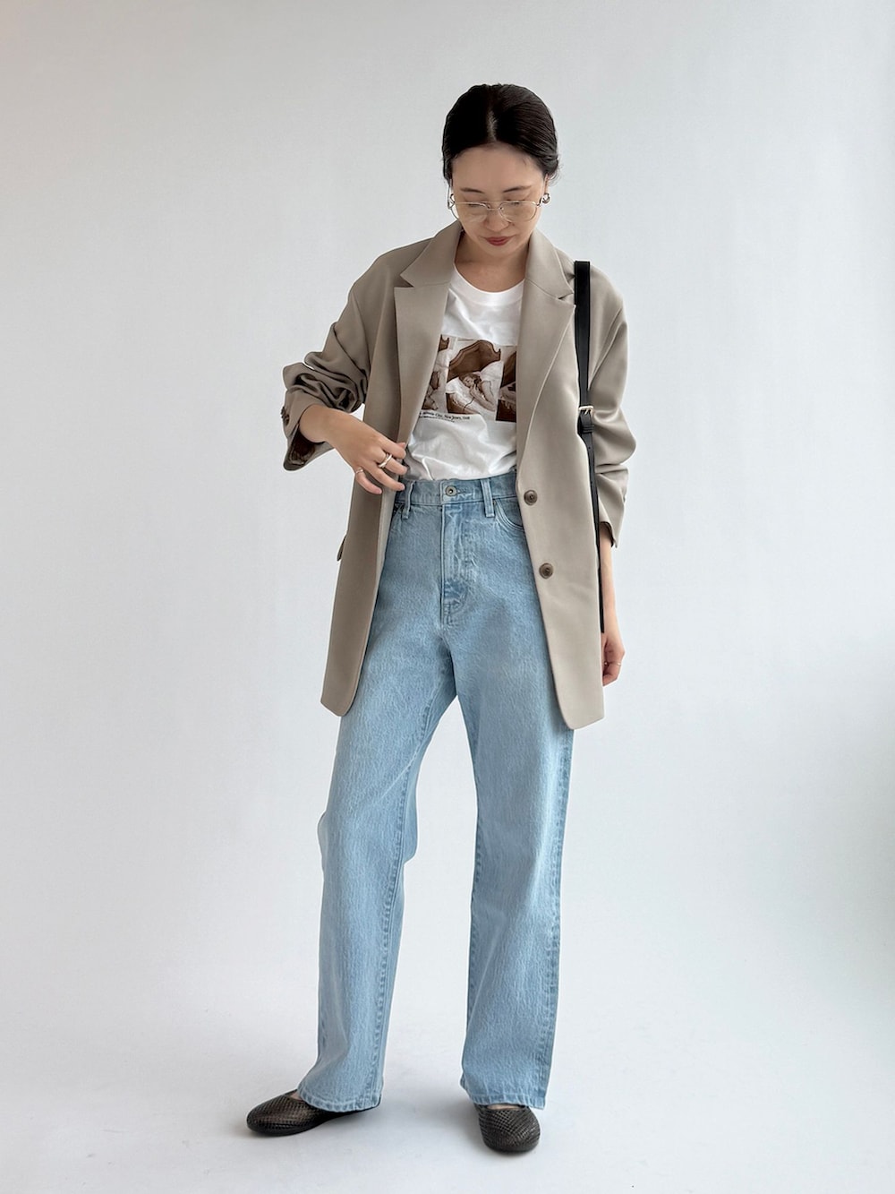 ブルー系のデニムパンツ、ベージュ系のテーラードジャケット、ホワイト系のTシャツ/カットソーを着用したレディースの春コーディネートの2枚目の写真