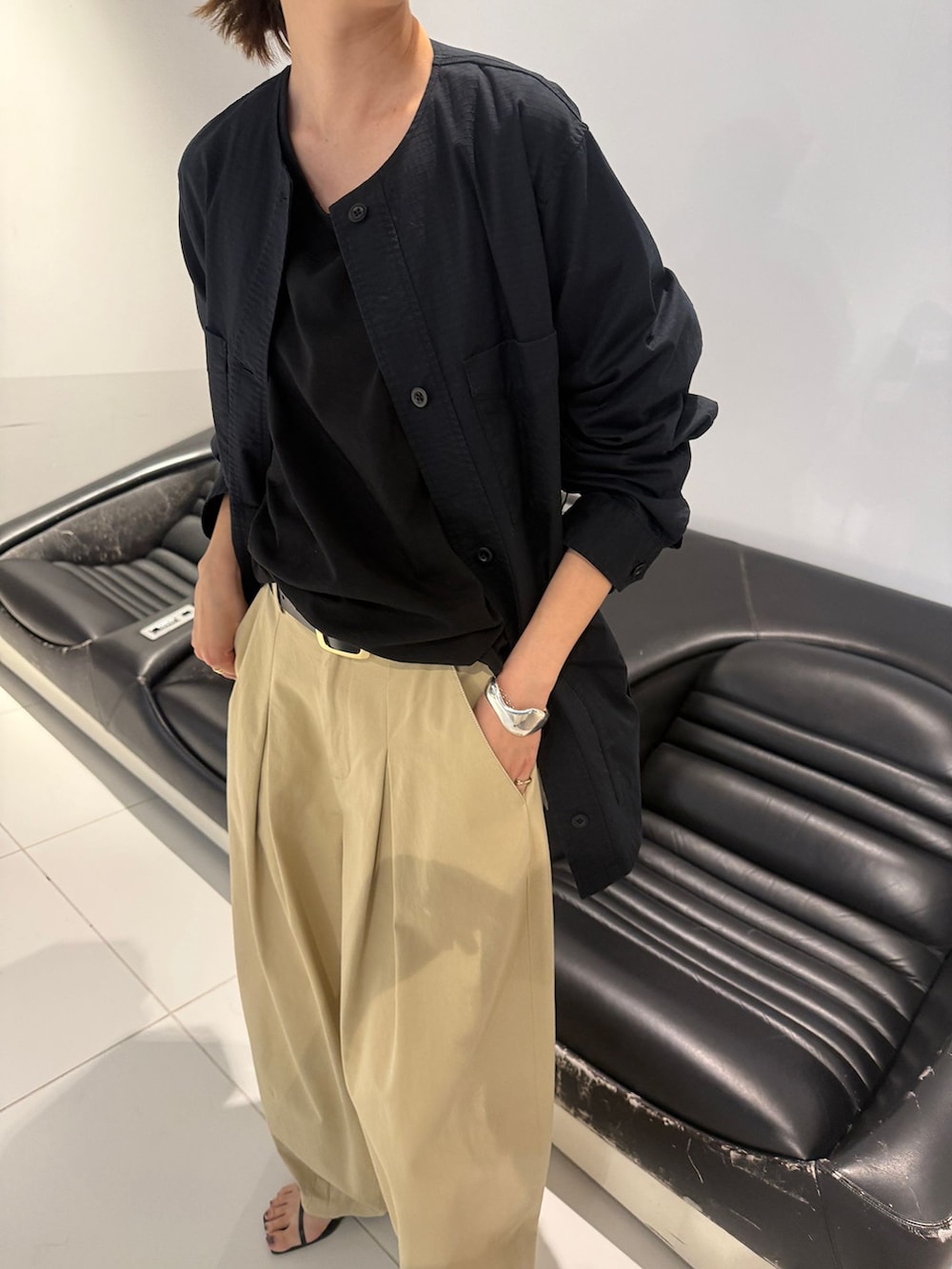 ベージュ系のチノパンツ、ブラック系のその他アウター、ブラック系のTシャツ/カットソーを着用したレディースの冬コーディネートの6枚目の写真