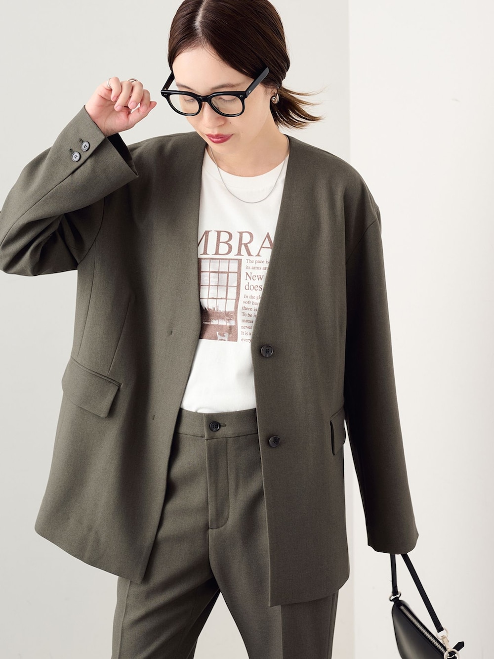 グリーン系のその他アウター、グリーン系のスラックス、ホワイト系のTシャツ/カットソーを着用したレディースの秋コーディネートの6枚目の写真