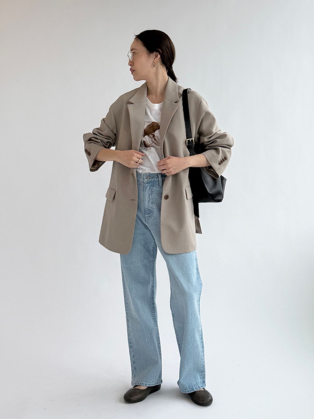ブルー系のデニムパンツ、ベージュ系のテーラードジャケット、ホワイト系のTシャツ/カットソーを着用したレディースの春コーディネートの3枚目の写真