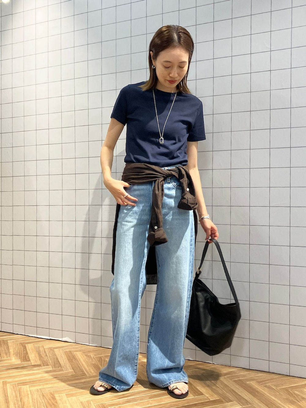ブルー系のその他パンツ、ブラウン系のシャツ/ブラウス、ブラック系のショルダーバッグを着用したレディースの春コーディネートの2枚目の写真