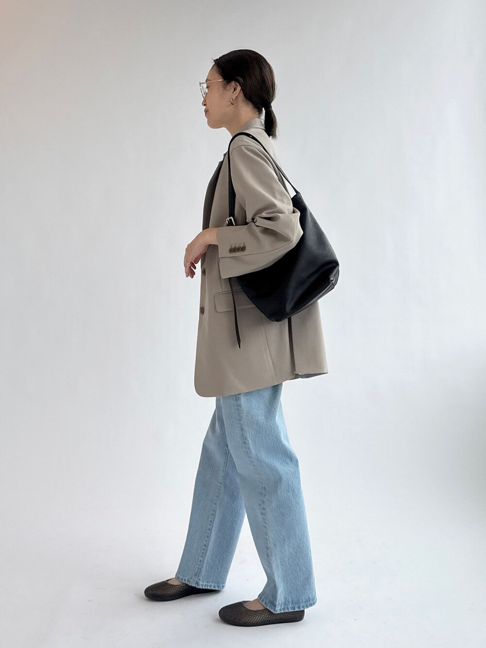 ブルー系のデニムパンツ、ベージュ系のテーラードジャケット、ホワイト系のTシャツ/カットソーを着用したレディースの春コーディネートの5枚目の写真
