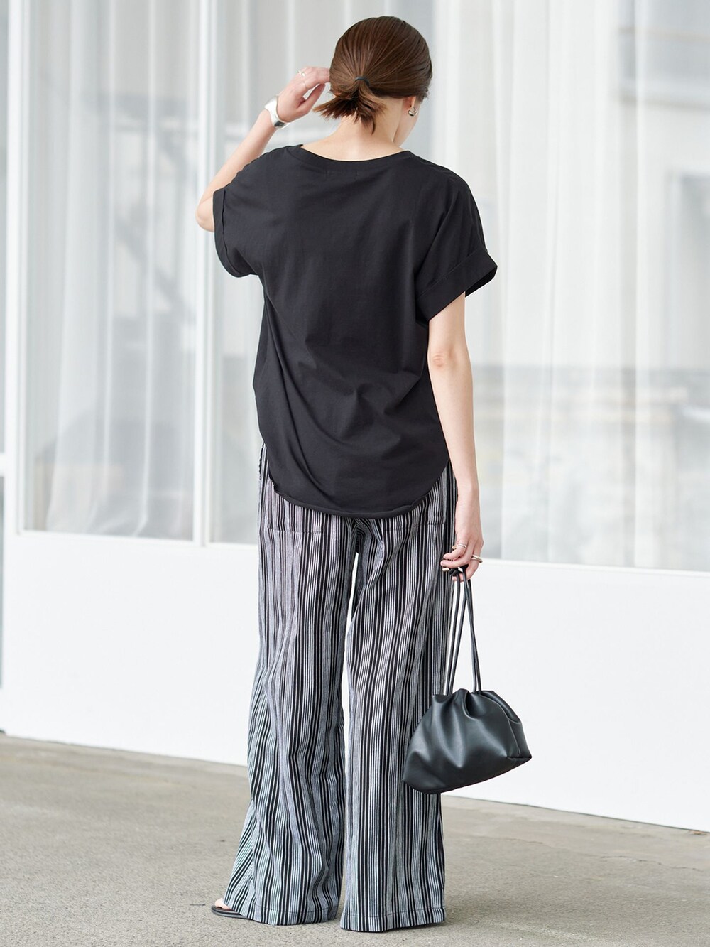ブラック系のその他パンツ、ブラック系のTシャツ/カットソー、ブラック系のクラッチバッグを着用したレディースの夏コーディネートの3枚目の写真