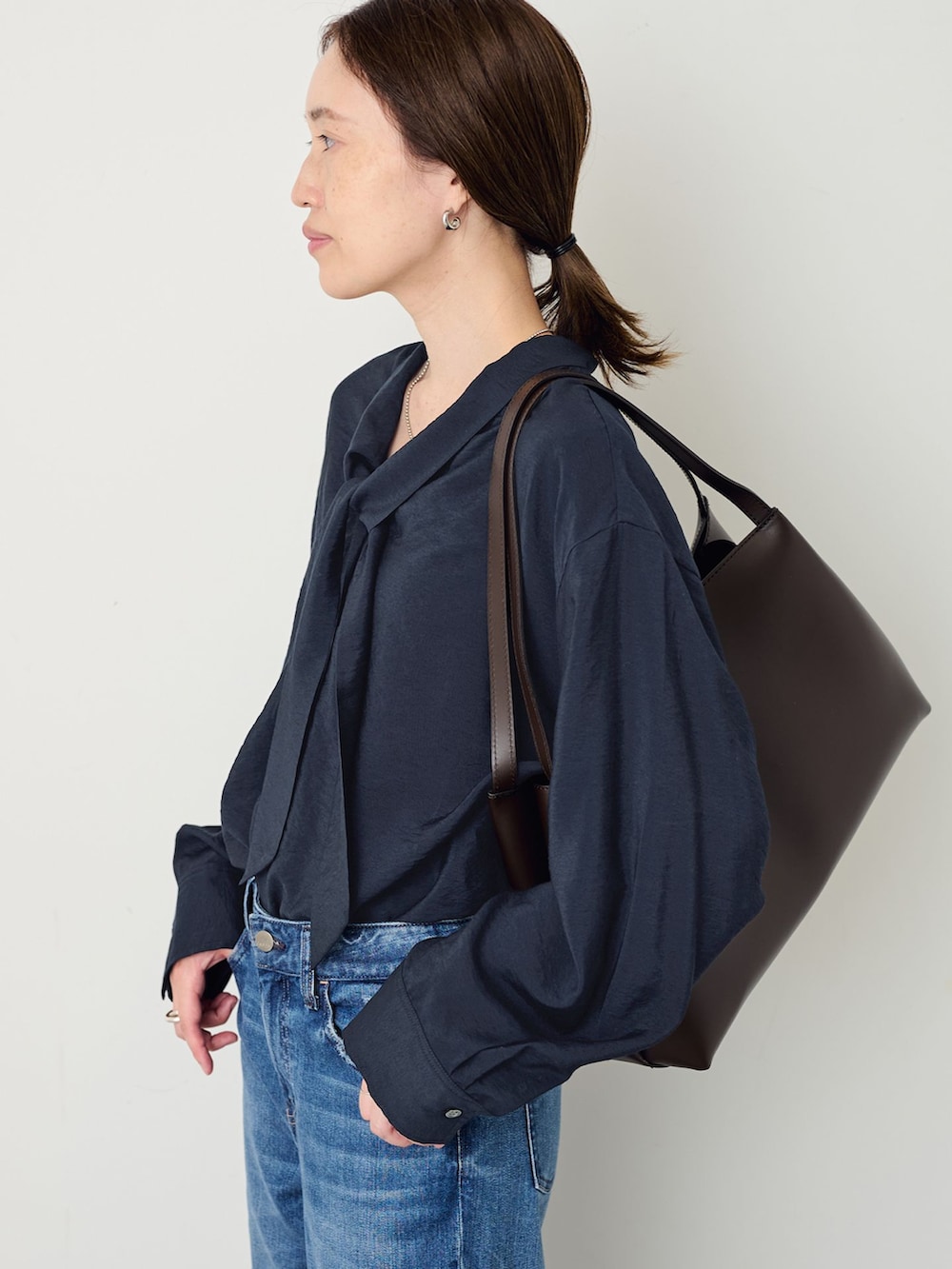ブルー系のデニムパンツ、ブルー系のシャツ/ブラウス、ブラウン系のトートバッグを着用したレディースの夏コーディネートの5枚目の写真