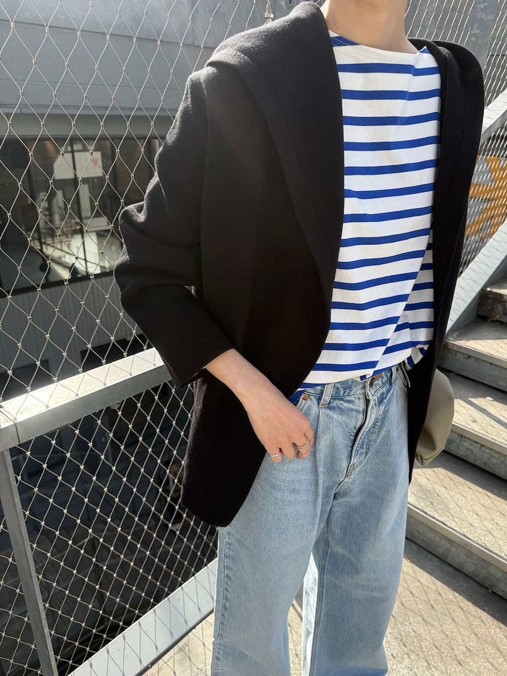 ブルー系のデニムパンツ、ブルー系のTシャツ/カットソー、ブラック系のカーディガン/ボレロを着用したレディースの春コーディネートの7枚目の写真