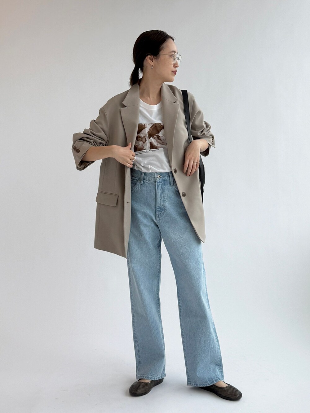 ブルー系のデニムパンツ、ベージュ系のテーラードジャケット、ホワイト系のTシャツ/カットソーを着用したレディースの春コーディネートの4枚目の写真