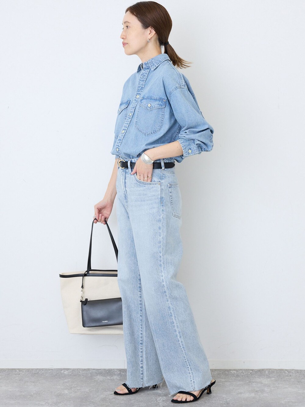 ブルー系のデニムパンツ、ブルー系のシャツ/ブラウス、ブラック系のサンダルを着用したレディースの夏コーディネートの3枚目の写真