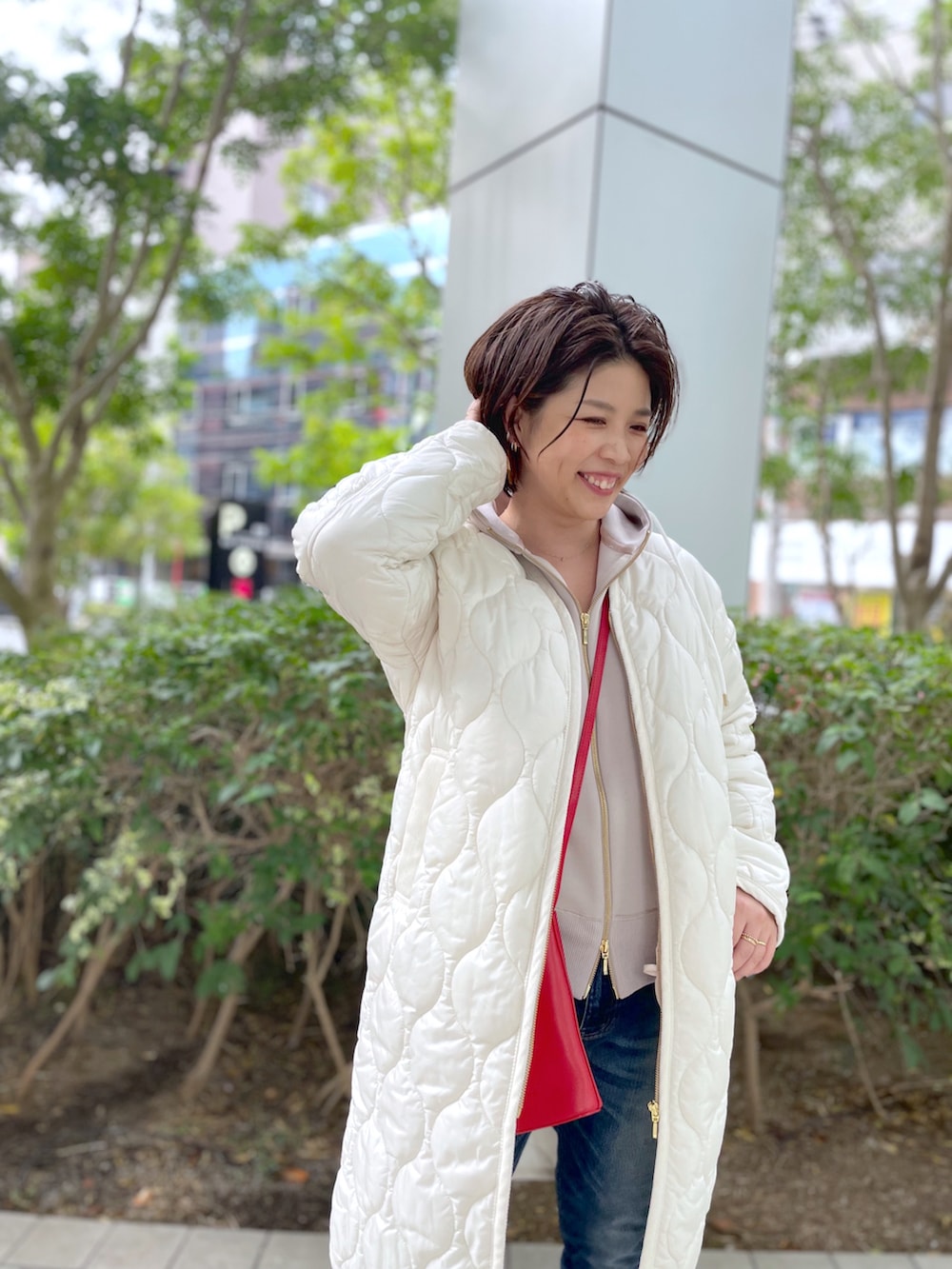 ブルー系のデニムパンツ、ブラック系のブーツ、ベージュ系のパーカーを着用したレディースの秋コーディネートの5枚目の写真