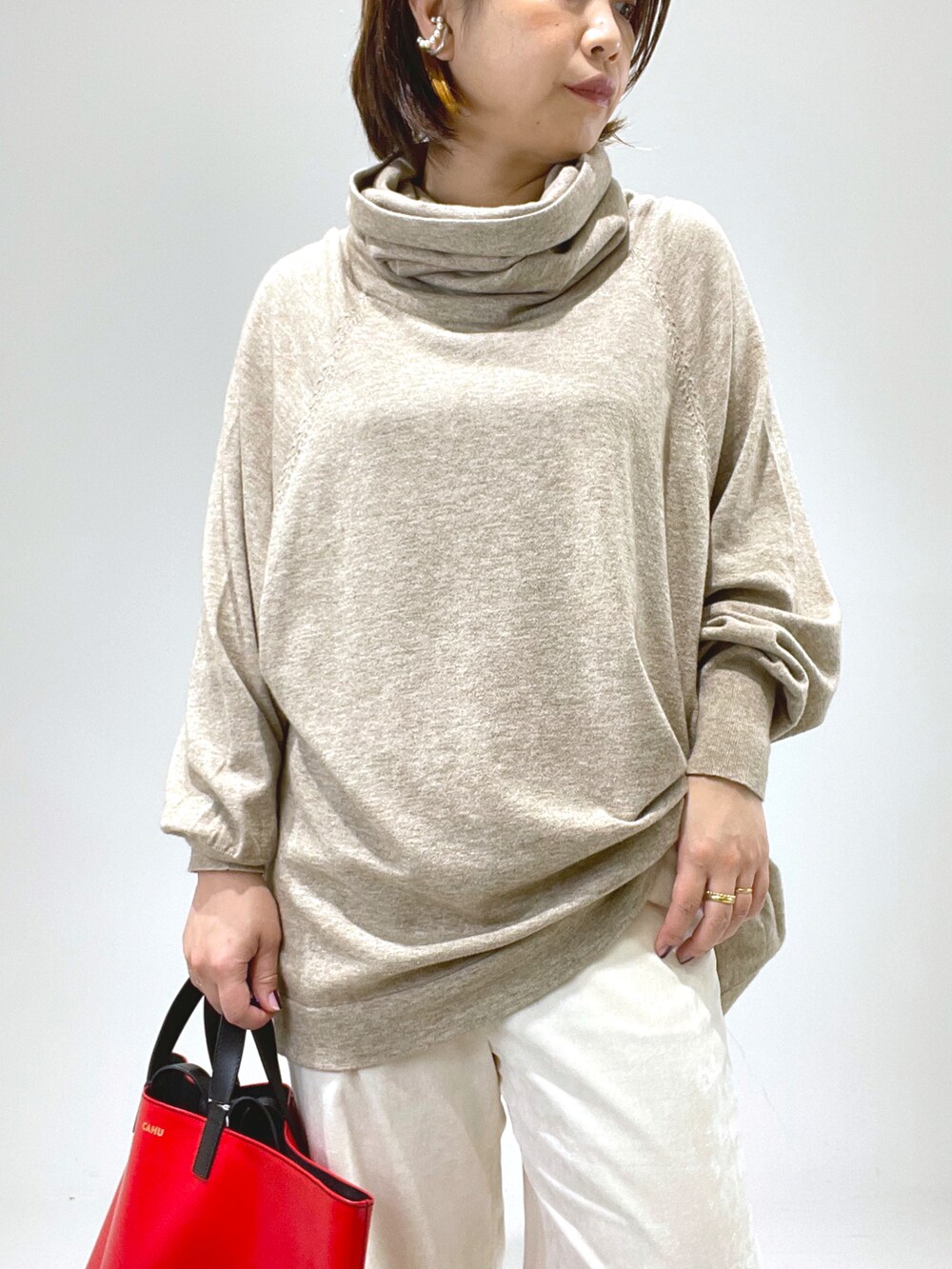 レッド系のトートバッグ、ホワイト系のその他パンツ、ベージュ系のブーツを着用したレディースの冬コーディネートの4枚目の写真