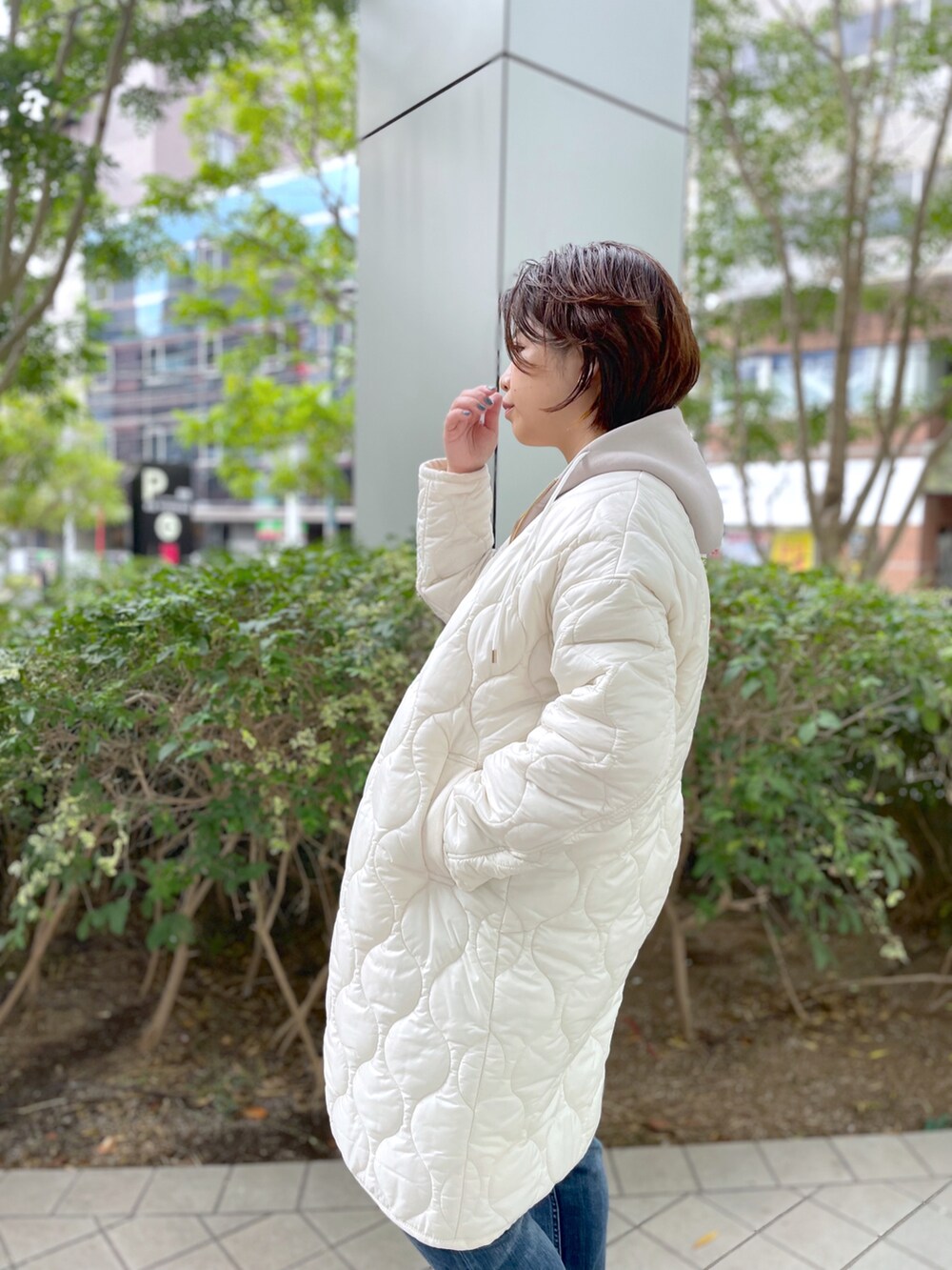 ブルー系のデニムパンツ、ブラック系のブーツ、ベージュ系のパーカーを着用したレディースの秋コーディネートの3枚目の写真