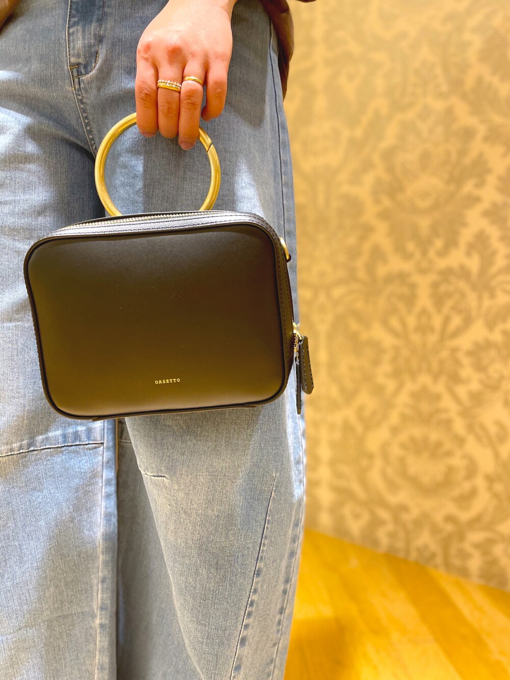 ブラック系のパンプス、ブルー系のデニムパンツ、ブラック系のショルダーバッグを着用したレディースの冬コーディネートの3枚目の写真