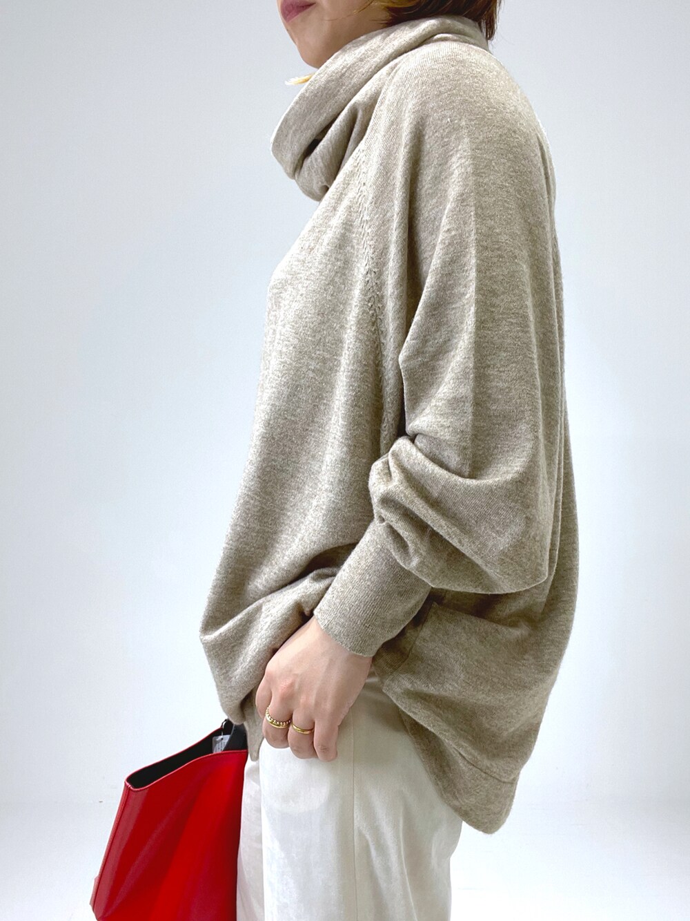 レッド系のトートバッグ、ホワイト系のその他パンツ、ベージュ系のブーツを着用したレディースの冬コーディネートの2枚目の写真