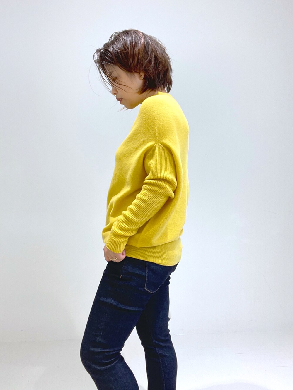 ブラック系のブーツ、イエロー系のトートバッグ、イエロー系のニット/セーターを着用したレディースの秋コーディネートの4枚目の写真