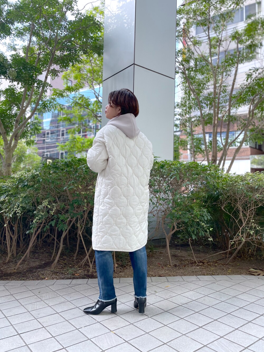 ブルー系のデニムパンツ、ブラック系のブーツ、ベージュ系のパーカーを着用したレディースの秋コーディネートの4枚目の写真