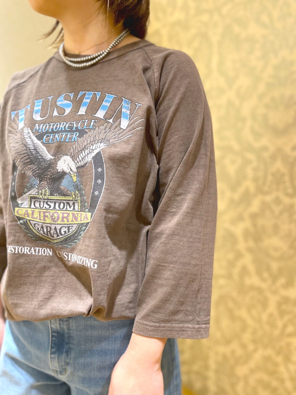 ブラック系のパンプス、ブルー系のデニムパンツ、ブラック系のショルダーバッグを着用したレディースの冬コーディネートの2枚目の写真