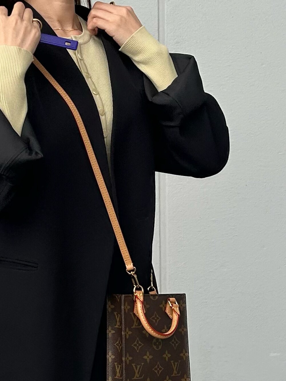 ブラック系のスカート、ブラック系のブーツ、ベージュ系のカーディガン/ボレロを着用したレディースの冬コーディネートの2枚目の写真