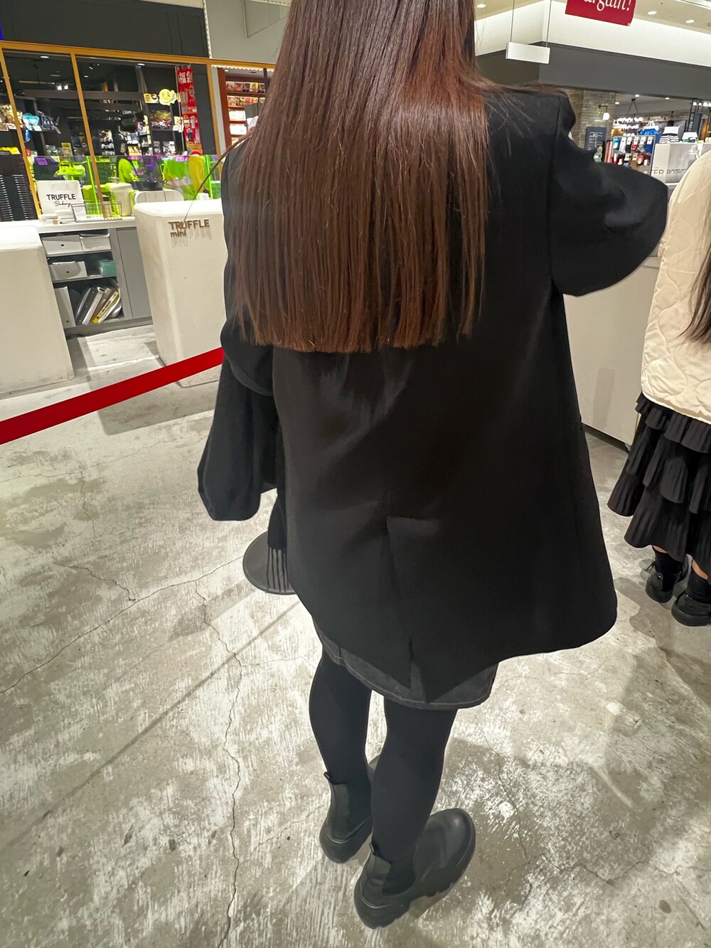 ブルー系のデニムスカート、ブラック系のブーツを着用したレディースの冬コーディネートの2枚目の写真