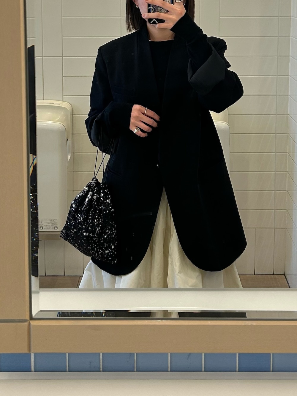 ホワイト系のスカート、ブラック系のブーツを着用したレディースの冬コーディネートの2枚目の写真