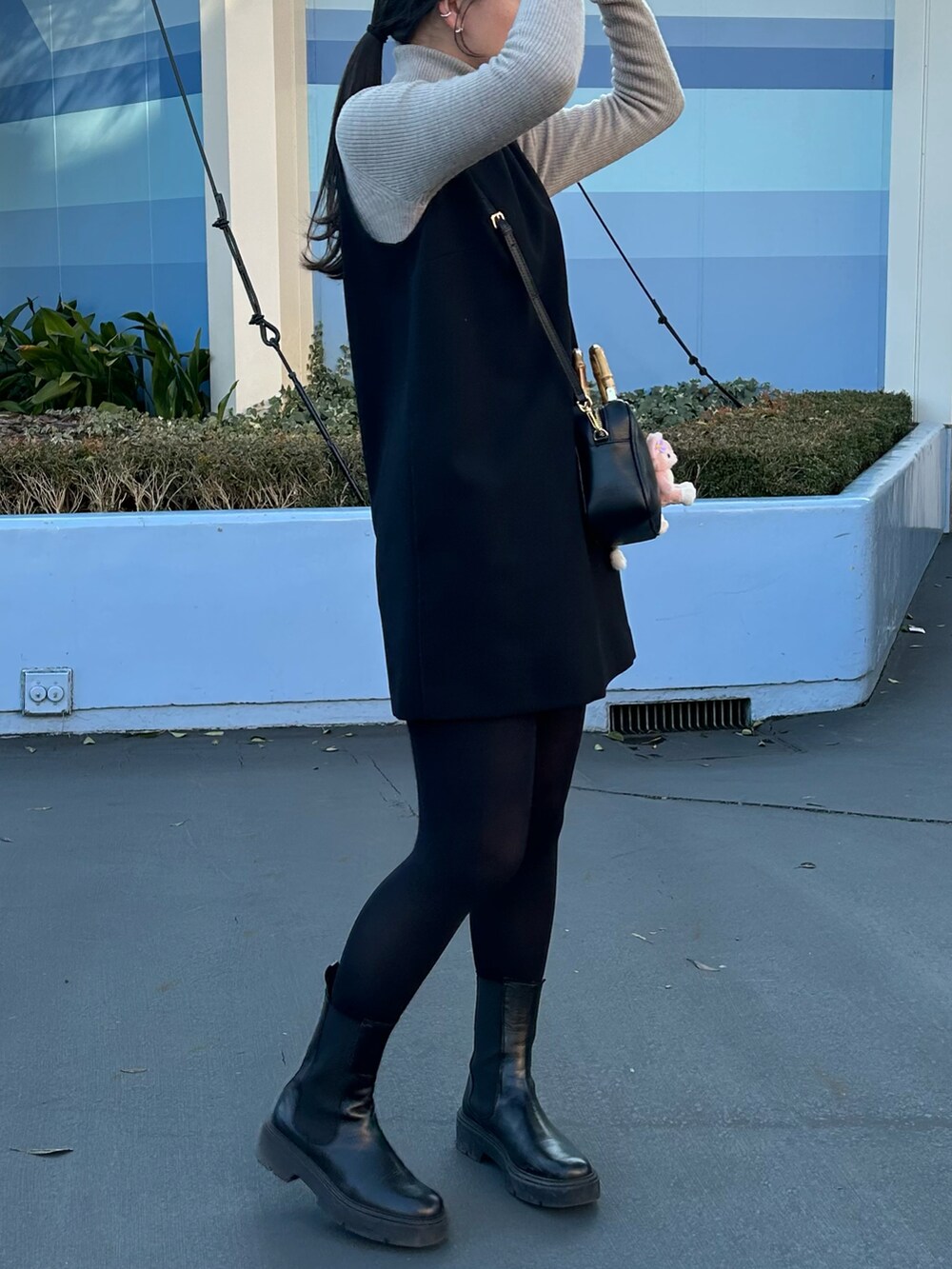 ブラック系のノーカラーコート、ブラック系のブーツを着用したレディースの冬コーディネートの2枚目の写真