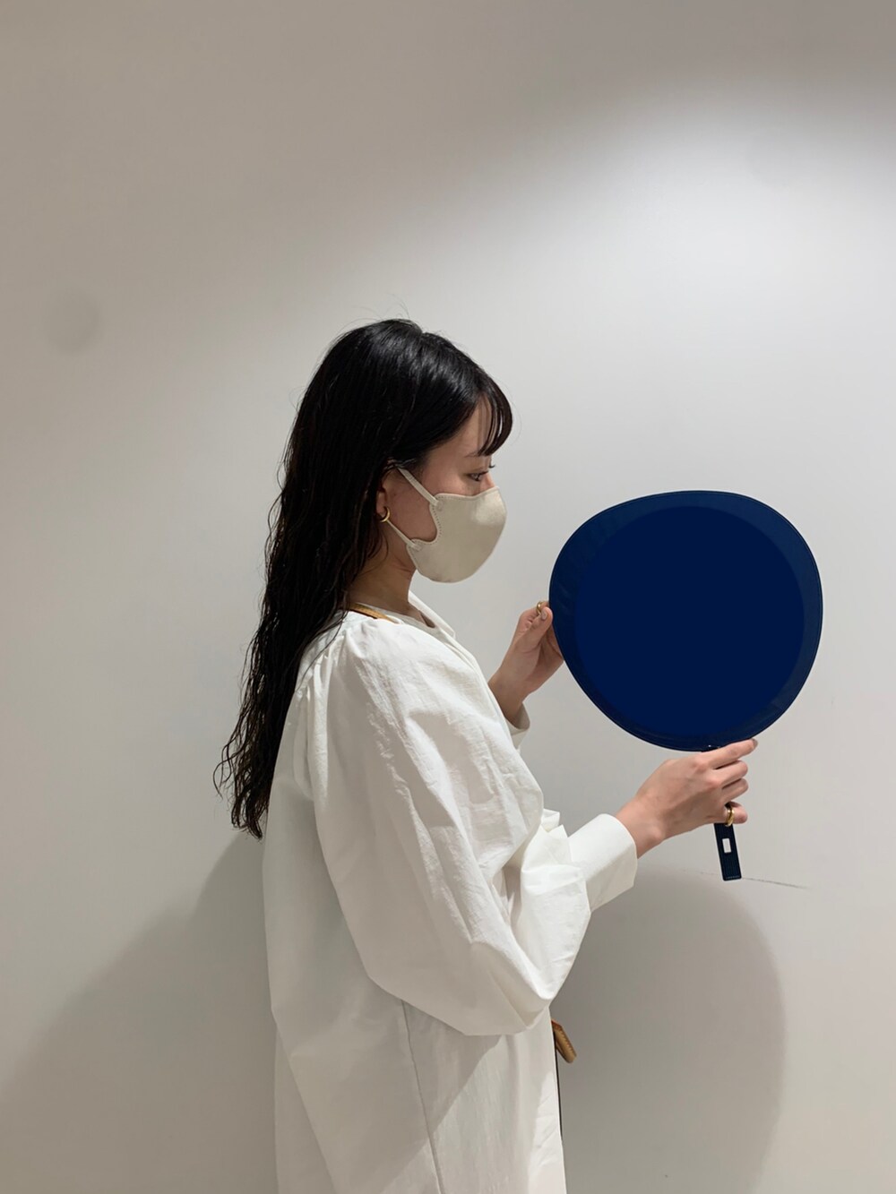 ホワイト系のワンピース、ブラック系のブーツ、ブラウン系のショルダーバッグを着用したレディースの春コーディネートの2枚目の写真