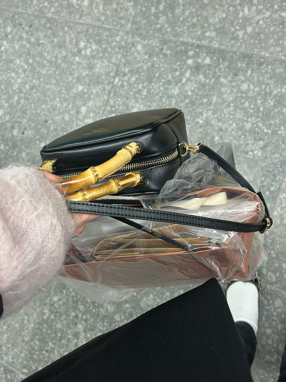 ピンク系のニット/セーター、ブラック系のデニムパンツ、ブラック系のショルダーバッグを着用したレディースの春コーディネートの3枚目の写真