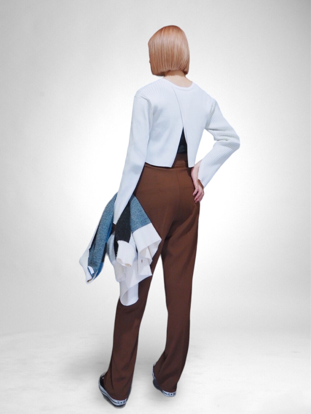 ブラウン系のスラックス、ホワイト系のニット/セーター、ブルー系のカーディガン/ボレロを着用したレディースの秋コーディネートの2枚目の写真