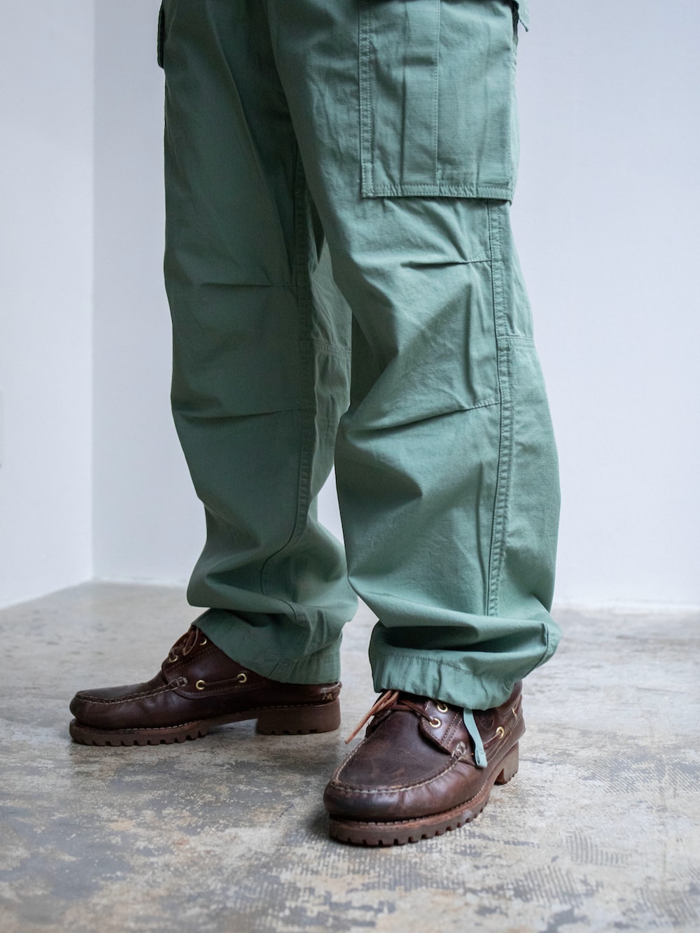 ベージュ系のパーカー、グリーン系のカーゴパンツ、グリーン系のニットキャップ/ビーニーを着用したメンズの春コーディネートの5枚目の写真