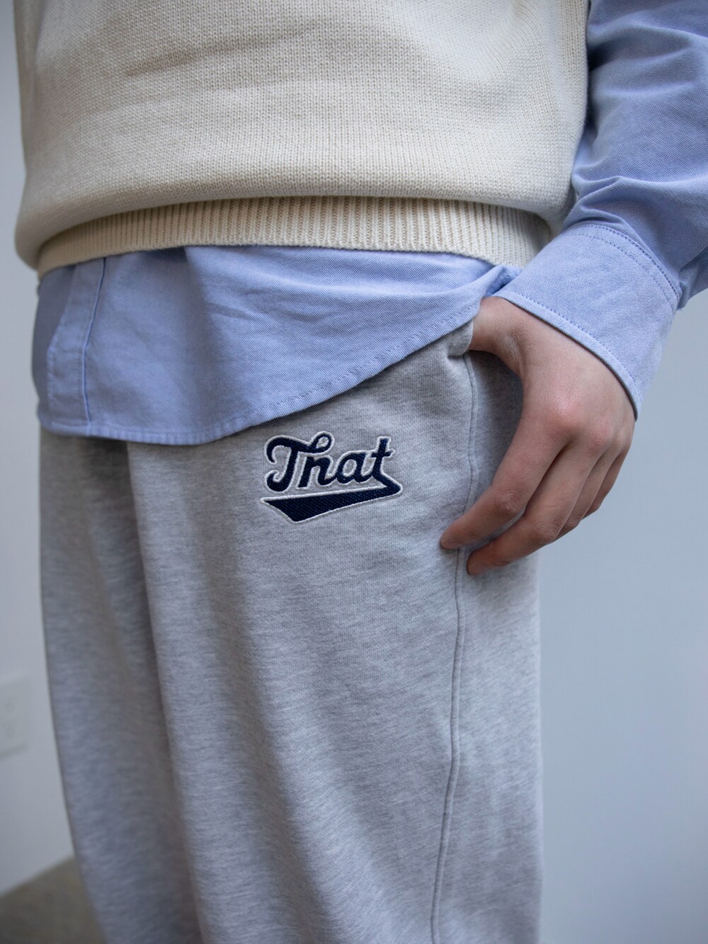 ホワイト系のベスト、ブルー系のシャツ/ブラウス、グレー系のスウェットパンツを着用したレディースの春コーディネートの3枚目の写真