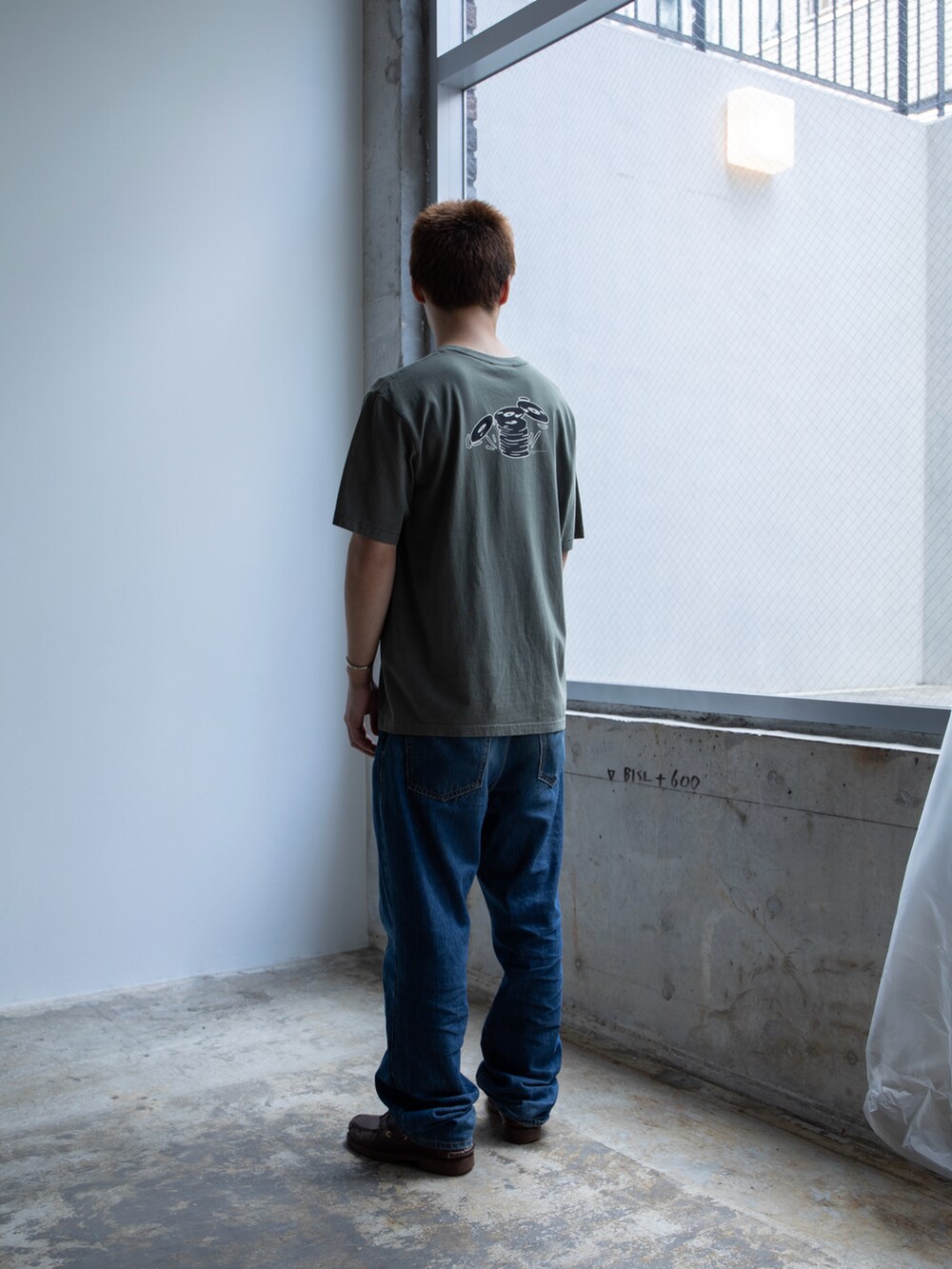 グリーン系のTシャツ/カットソー、ブルー系のデニムパンツを着用したメンズの春コーディネートの2枚目の写真