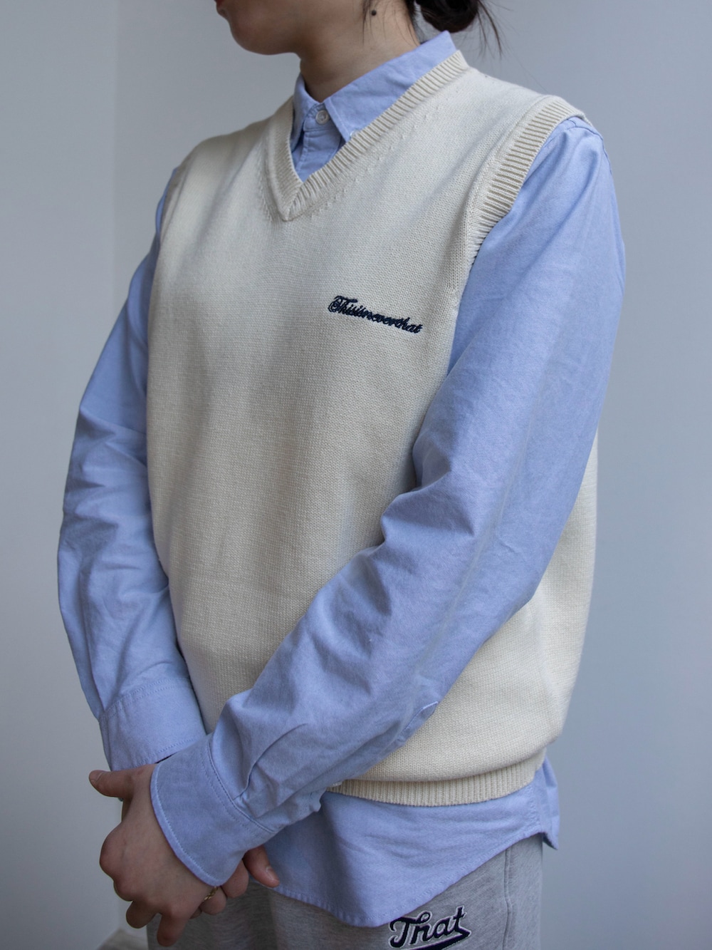 ホワイト系のベスト、ブルー系のシャツ/ブラウス、グレー系のスウェットパンツを着用したレディースの春コーディネートの2枚目の写真